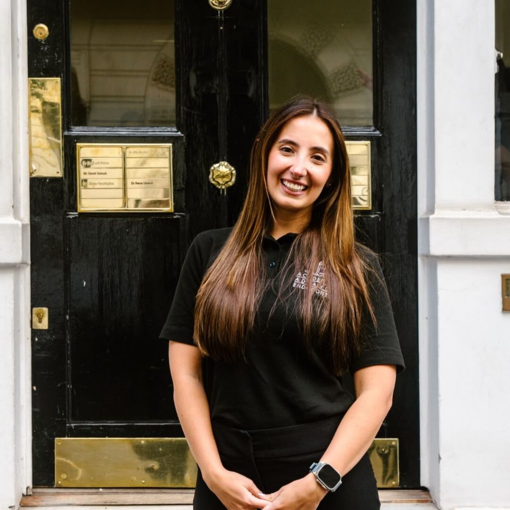 Receptionist, Katherine Fernandes, standing outside of the dental practice in London