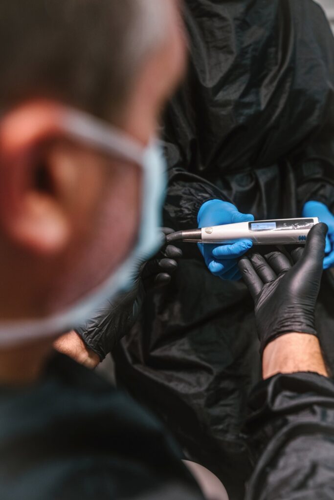 Male endodontist passing a dental tool to another team member