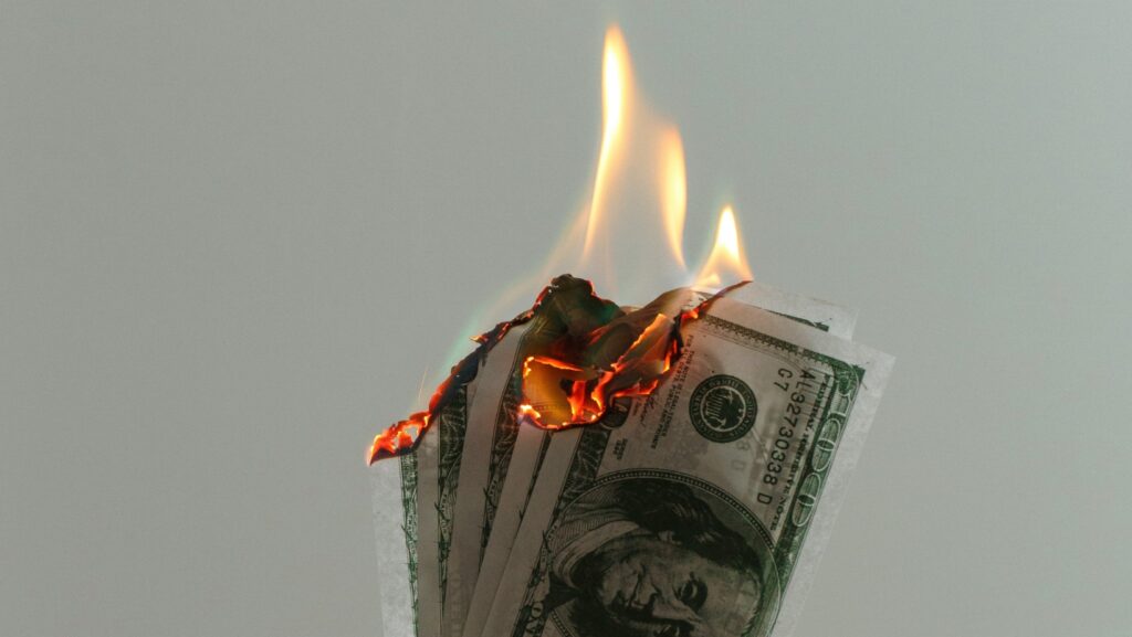 A wad of American dollars burnt with flames
